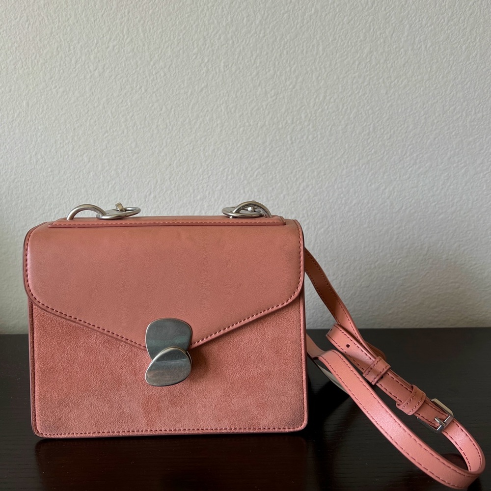It’s a brand new beautiful salmon pink crossbody bag. It has adjustable straps.
